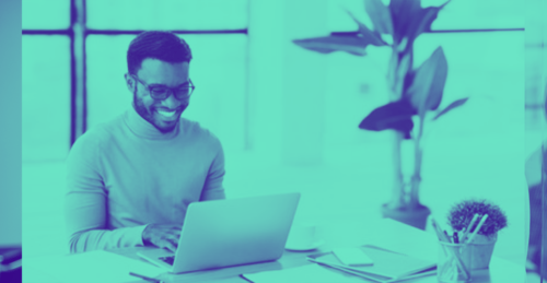 Smiling man using laptop at table
