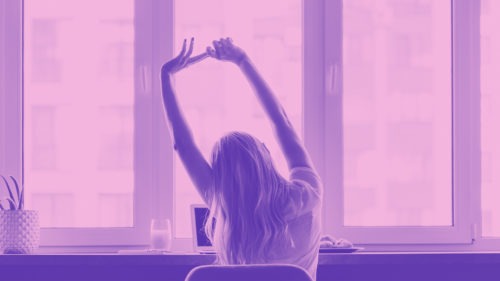 A female worker stretches at a desk